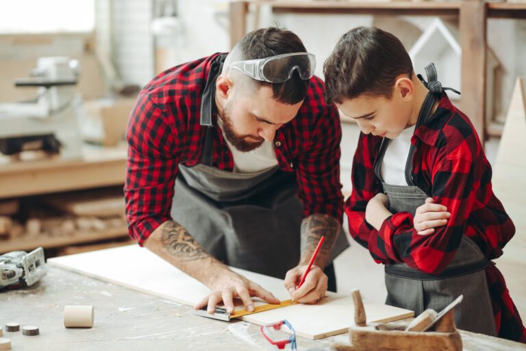 Men with ruler and pencil measuring wooden plank for work