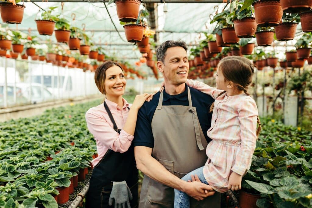 Happy family communicating while working in their greenhouse.